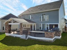 a large house with an outdoor grill in the yard