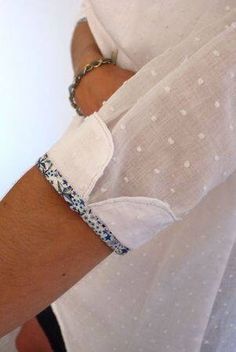 a person wearing a white shirt and blue bracelet