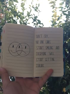 someone is holding an open notebook with writing on it that says don't cry, no one cares start smiling and everyone will start getting ted