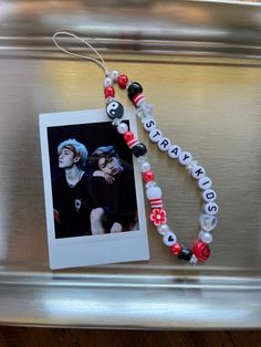 a silver tray with a photo and beaded necklace on it