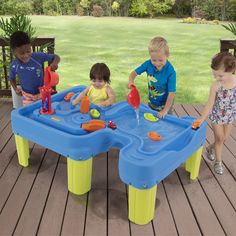 three children playing in a water table on a deck