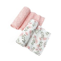 three pink and white floral blankets folded on top of each other, with one rolled up