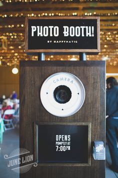 an old fashioned photo booth is displayed for people to take pictures in the background with lights