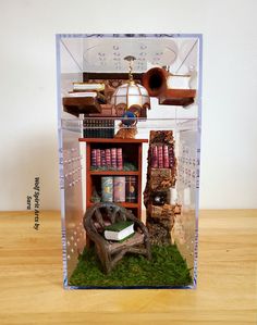 a miniature book shelf with books and other items in it