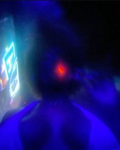 a blurry image of a cell phone with red light in the back and blue lights behind it