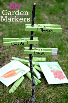 a diy garden marker tree made out of clothes pins and some cards on the ground