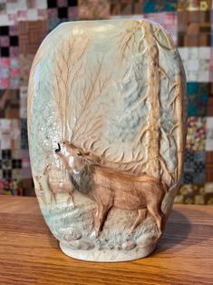 a ceramic animal vase sitting on top of a wooden table