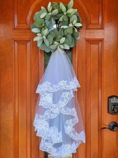 a wedding veil hanging on a door with a wreath in front of it that says, i do not know what this is