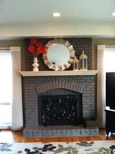 a living room with a fire place and a mirror on the fireplace mantels