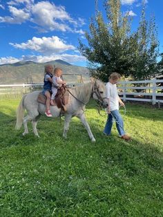 two children riding on the back of a horse