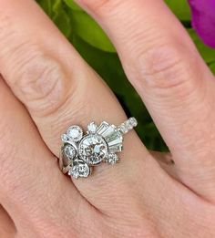 a close up of a person's hand with a diamond ring on their finger