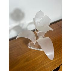 two glass flowers sitting on top of a wooden table