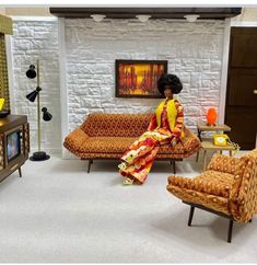 a woman sitting on top of a couch in a living room next to a tv