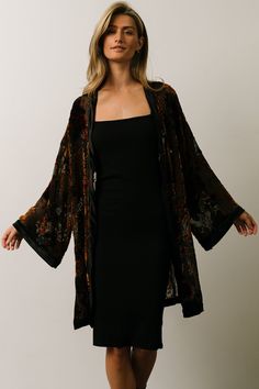 Baltic Born exclusive style! Black with bronze, deep red, and forest green floral Burnout velvet material with a velvet border Open front style Long kimono sleeves with velvet cuffs Slits on both sides 100% Polyester Skye is 5'9, cup size 32A, size 0 and wearing size S Jayci is 5'8", cup size 38 DD, and wearing size 1XL Black Velvet Kimono, Green Velvet Kimono, Black Velevet Dresses, Witchy Work Outfit, Forest Wedding Outfit, Woodsy Fashion, Sheer Kimono Outfit, Edgy Vintage Outfits, Witchy Fashion Modern Witch