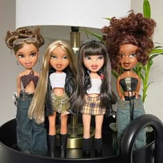 there are four dolls standing on the table next to each other in front of a lamp