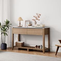 a wooden table with shoes on it in front of a white wall and potted plant