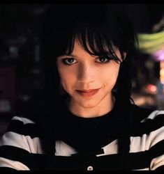 a close up of a person wearing a black and white striped shirt with dark hair