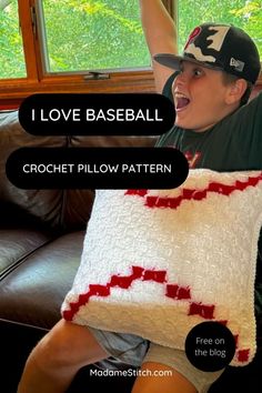 a person sitting on a couch with a pillow in the shape of a baseball bat