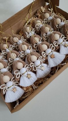 an open box filled with tassels and decorated eggs on top of wooden sticks