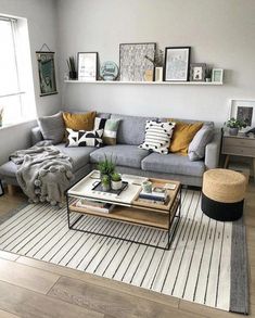 a living room with grey couches and yellow pillows on the wall above them is also a coffee table