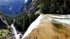 there is a waterfall in the middle of some mountains