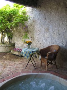 a hot tub sitting next to a table with flowers on it