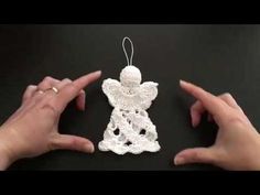 two hands holding an ornament in the shape of a angel