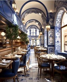 a restaurant with blue and white walls and tables set up for two people to eat