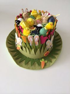 there is a cake decorated with animals and flowers on the top, sitting on a green plate