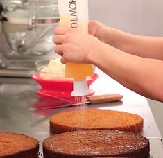 a person is pouring liquid onto some cakes