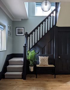 a stair case next to a set of stairs with a plant on the bench in front of it