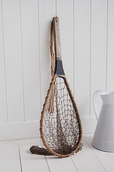 a tennis racquet is hanging on the wall next to a white pitcher and vase