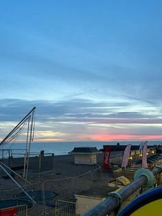 the sun is setting on an empty beach