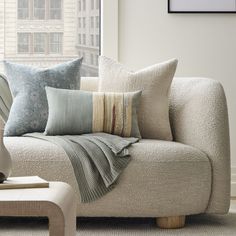 a couch with pillows on it in front of a window