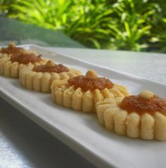 some food is sitting on a white plate and there are sauces in the middle