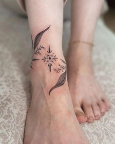 a woman's foot with a small flower tattoo on it