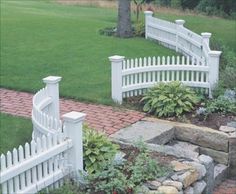 a white picket fence in the middle of a yard