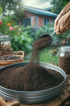 a person scooping coffee beans into a metal bowl on top of a wooden table