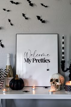 a white table topped with halloween decorations and candles next to a sign that says welcome my prettiies