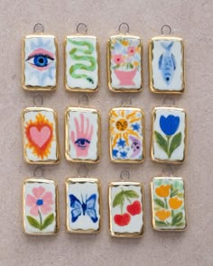 nine small square charms with flowers and hearts painted on them, all in different colors