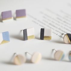 four pairs of earrings sitting on top of a piece of paper next to each other