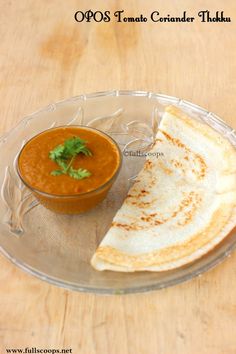 there is a bowl of soup and some pita bread on the plate next to it