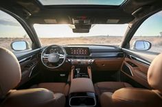 the interior of a vehicle with leather seats and dashboards, including steering wheel controls