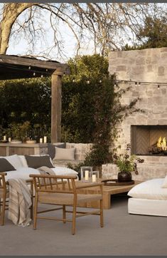 an outdoor living area with couches, chairs and fire place