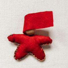 a red star brooch sitting on top of a white cloth