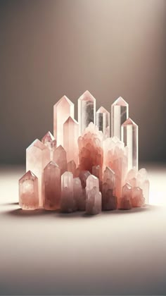 some pink crystals are sitting on the floor in front of a gray background with light coming from behind them