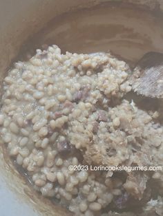 cooked beans and meat are mixed together in a bowl