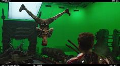 a man is suspended in the air on a green screen with his legs spread out