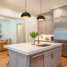 a kitchen with an island and two lights hanging over it's counter top,