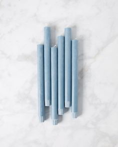 four blue candles sitting on top of a white counter